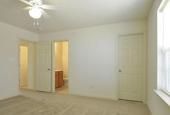 Bedroom with two doors and a ceiling fan at The Pointe at Manorgreen Townhomes, Maryland